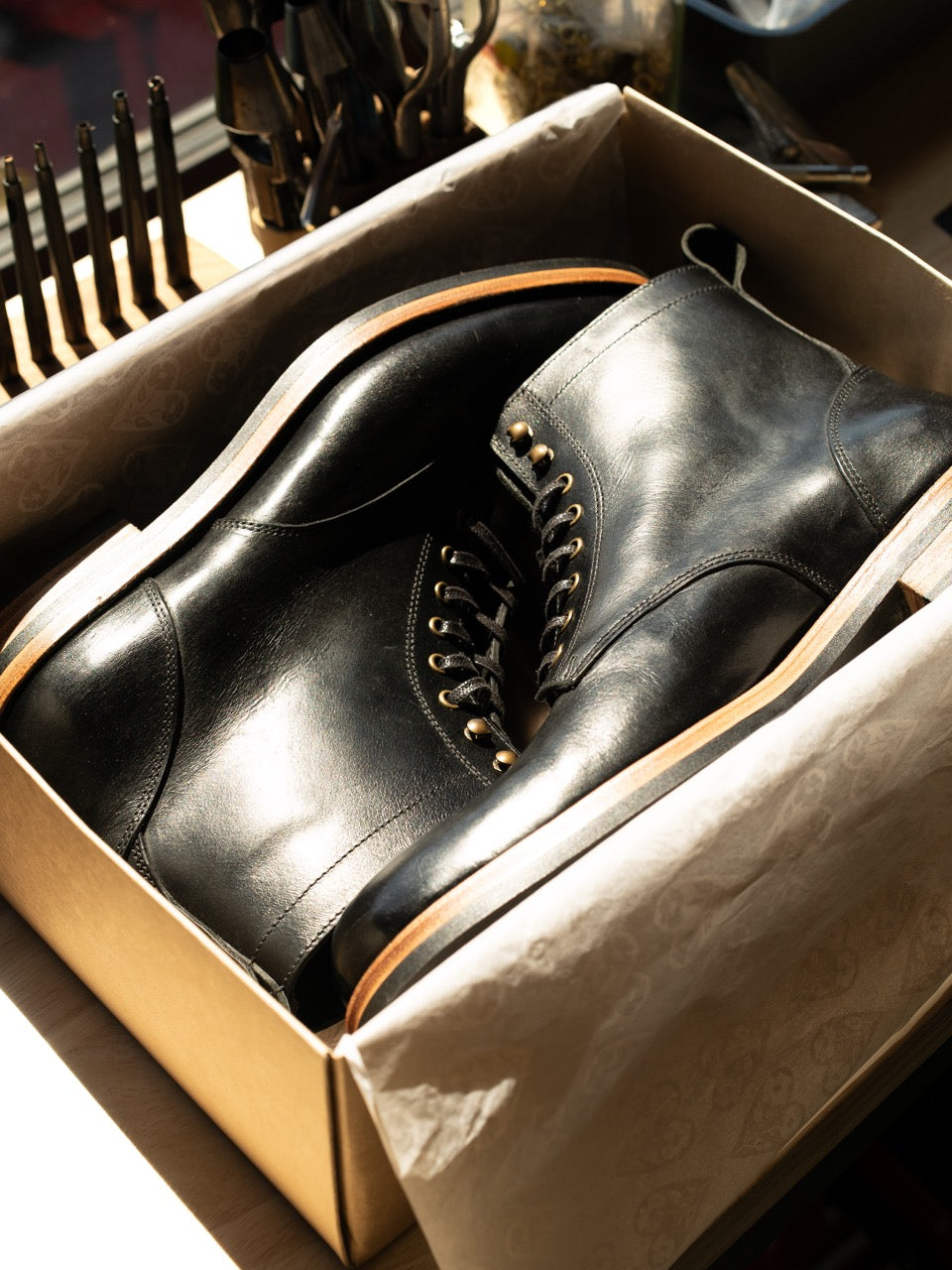 Black Derby Boots from Archive Leather Goods packed in their box with tissue paper.