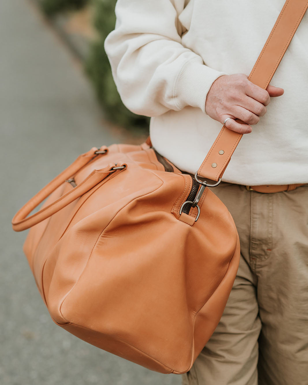 Un homme portant un Chabanel Weekender Bag d'Archive Leather Goods, en cuir Horween Essex naturel.