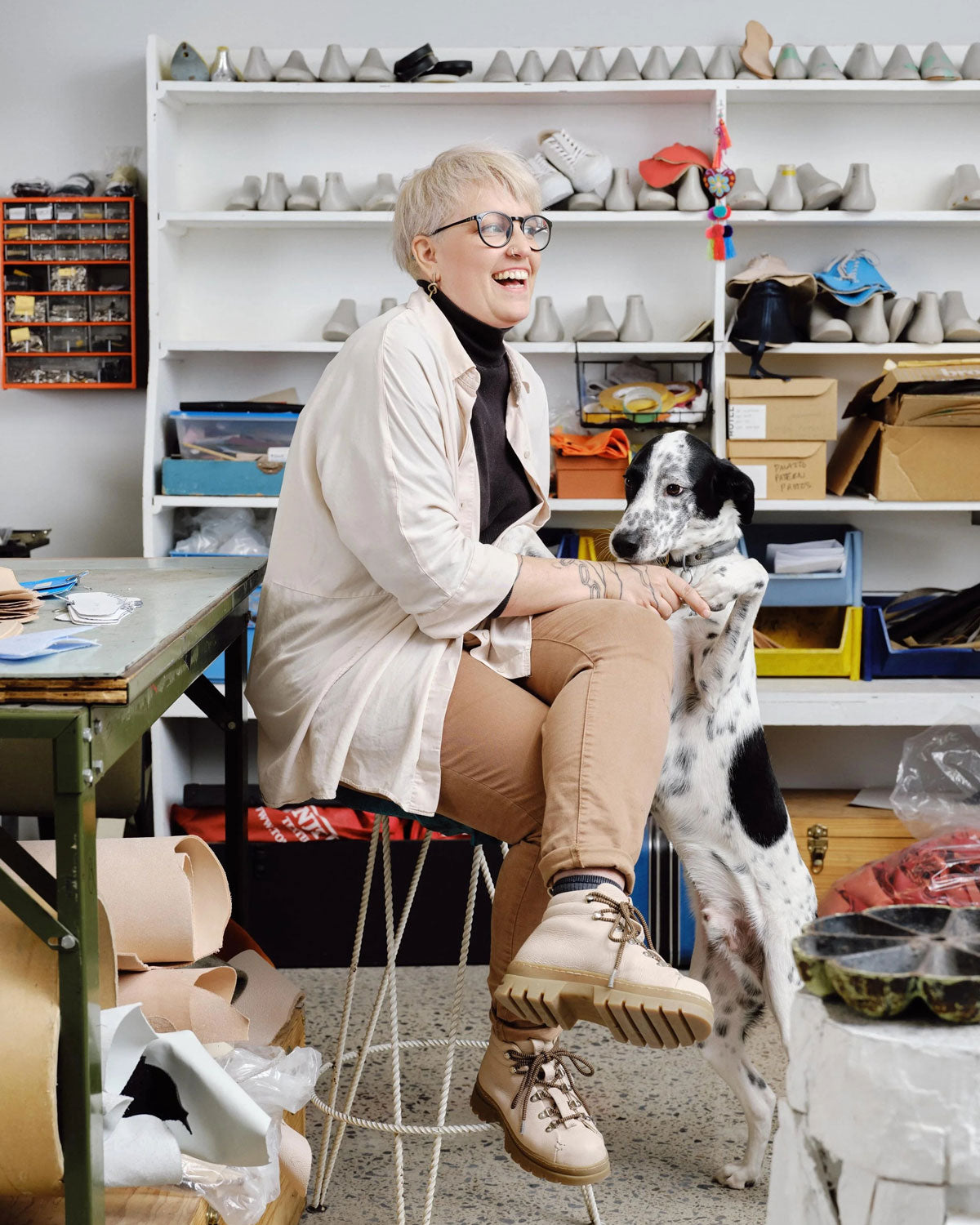 Corinne Bourget in her Montreal workshop, seated with her dog.